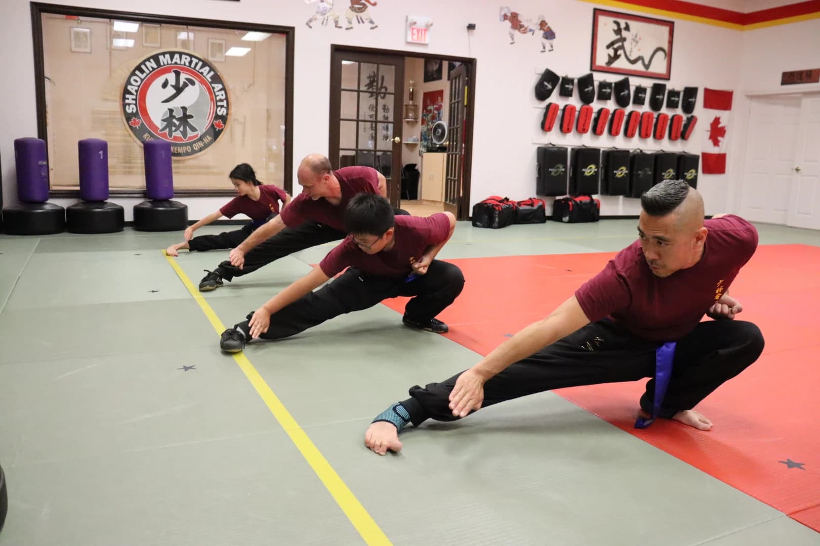 Teen and adult students practising deep stretching stances
