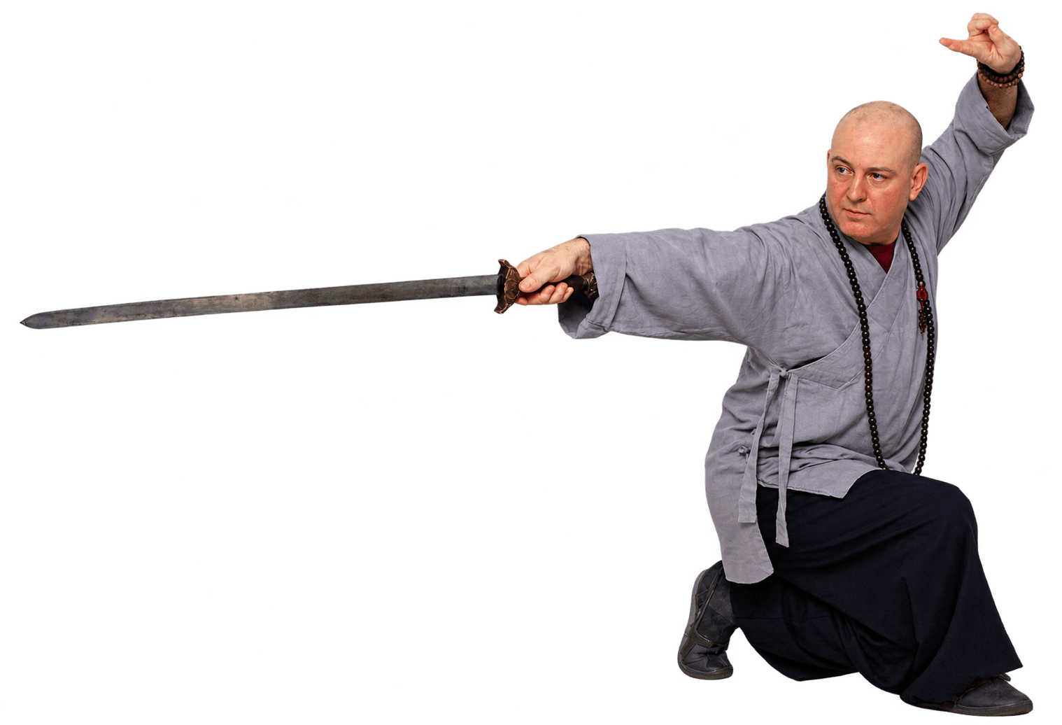 Shifu Tim Wakefield in grey robes holding a low stance with a straight sword